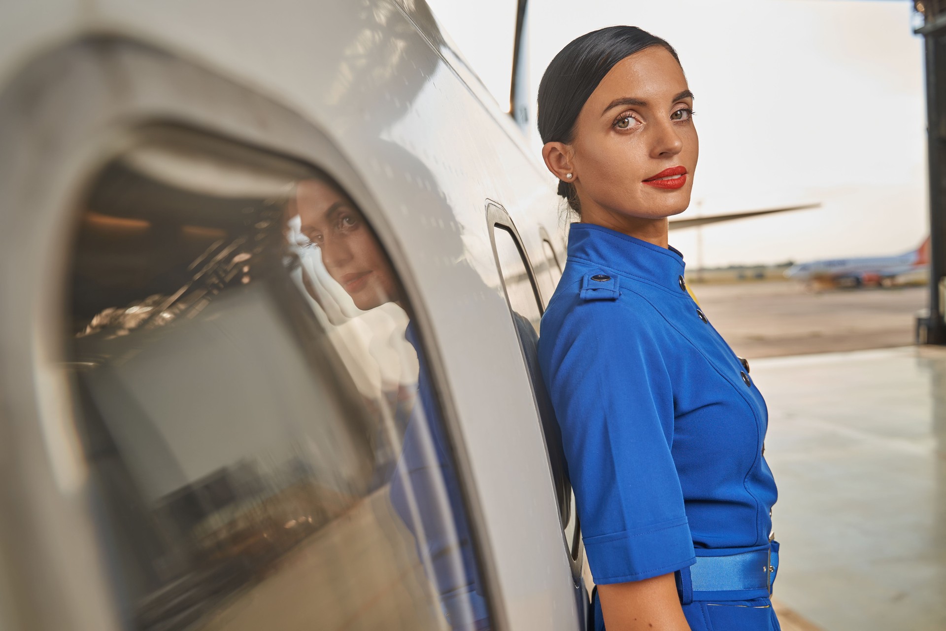 Portrait of the stewardess next to the aircraft outdoors